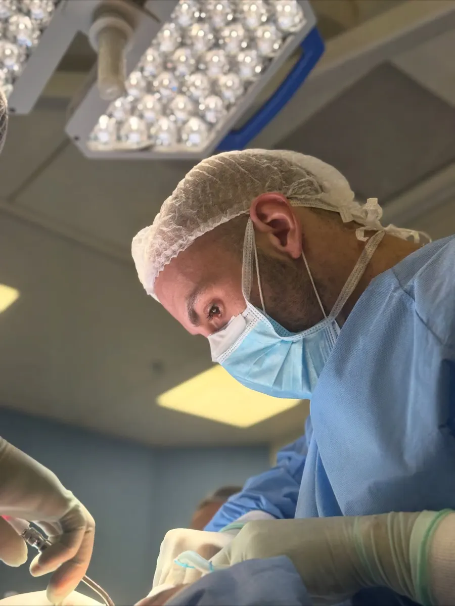 Dr. Felipe Gasques operando sob a luz do centro cirúrgico